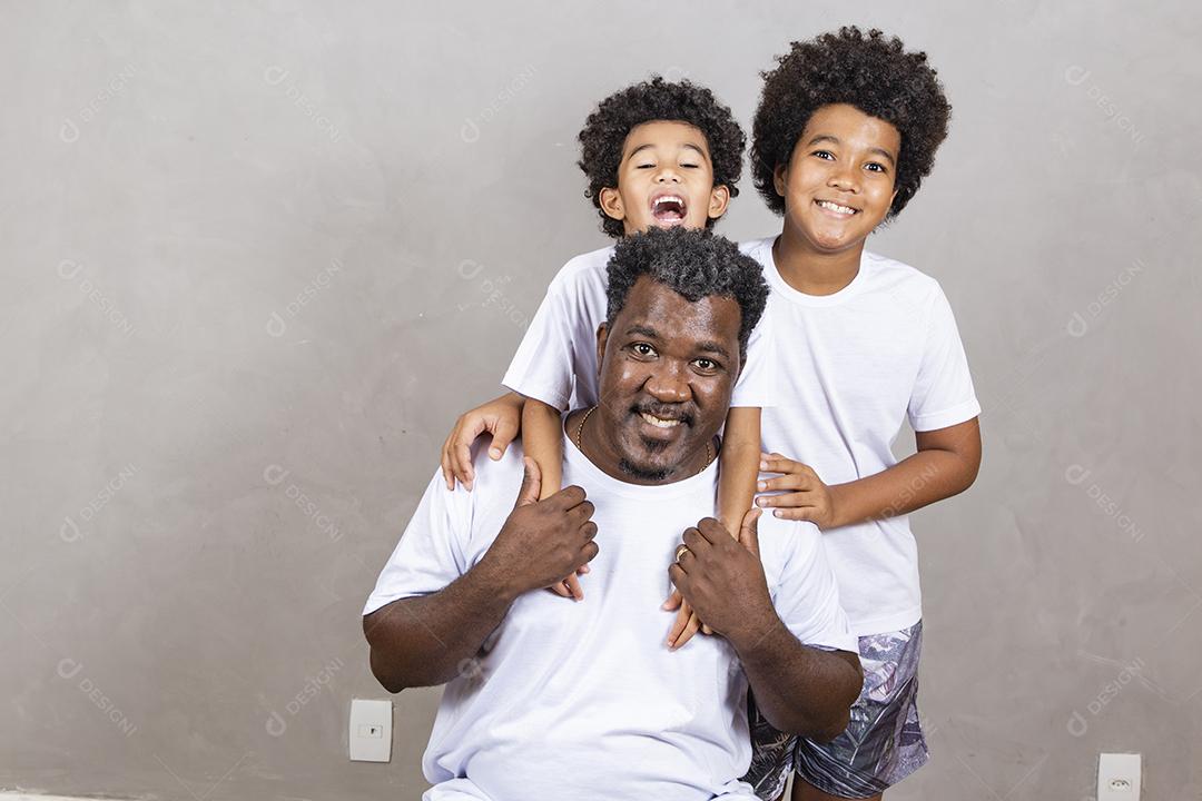 Dia dos Pais. Pai negro com seus dois filhos afro em fundo branco