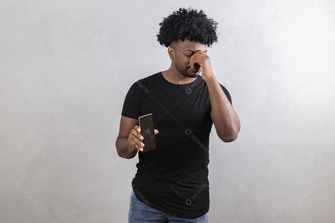 homem triste segurando um celular frustrado