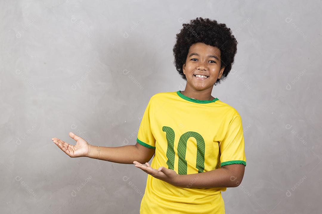 fã brasileiro sorridente apontando para o lado