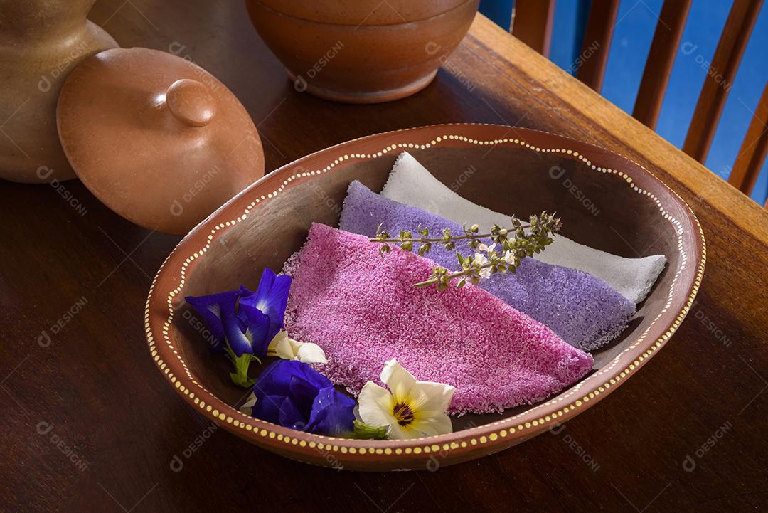 Tapioca. Tapiocas brasileiras coloridas servidas em tigelas de barro com flores silvestres no café da manhã.