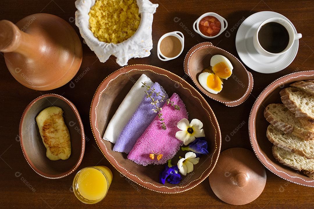 Tapioca. Tapiocas brasileiras coloridas servidas em tigelas de barro com flores silvestres no café da manhã.