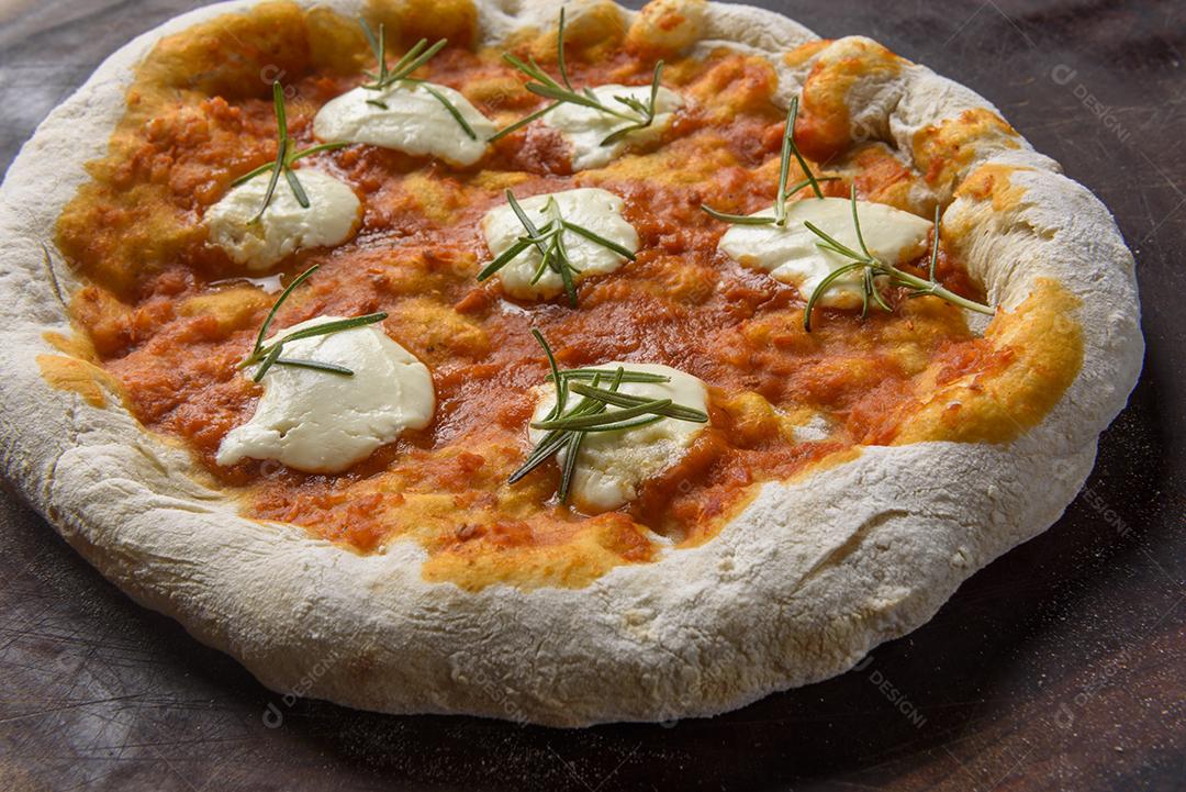 Pizza. Pizza caseira de queijo de cabra e alecrim na madeira.