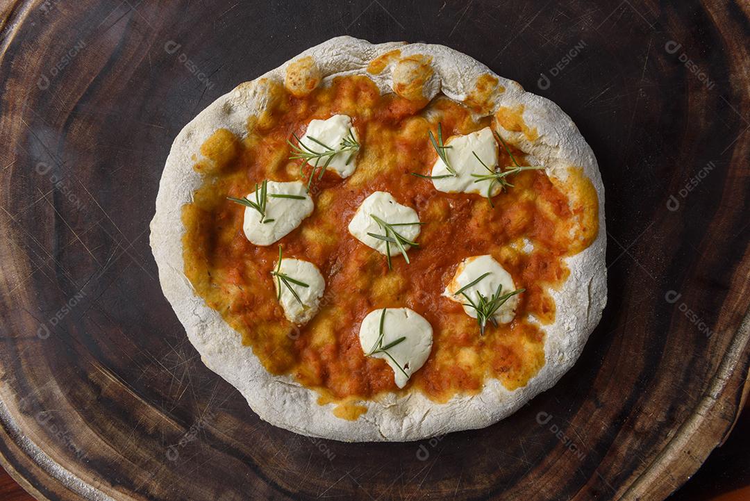 Pizza. Pizza caseira de queijo de cabra e alecrim na madeira.