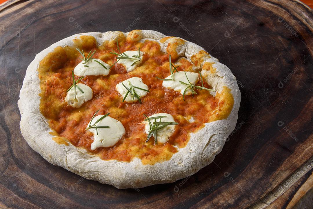 Pizza. Pizza caseira de queijo de cabra e alecrim na madeira.