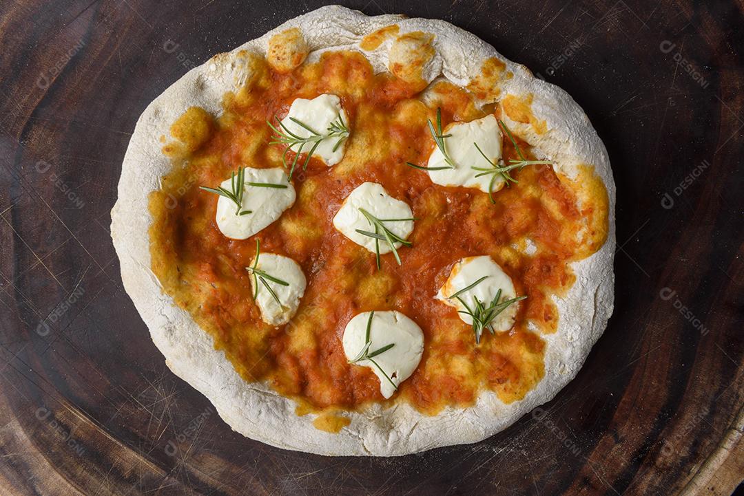 Pizza. Pizza caseira de queijo de cabra e alecrim na madeira.