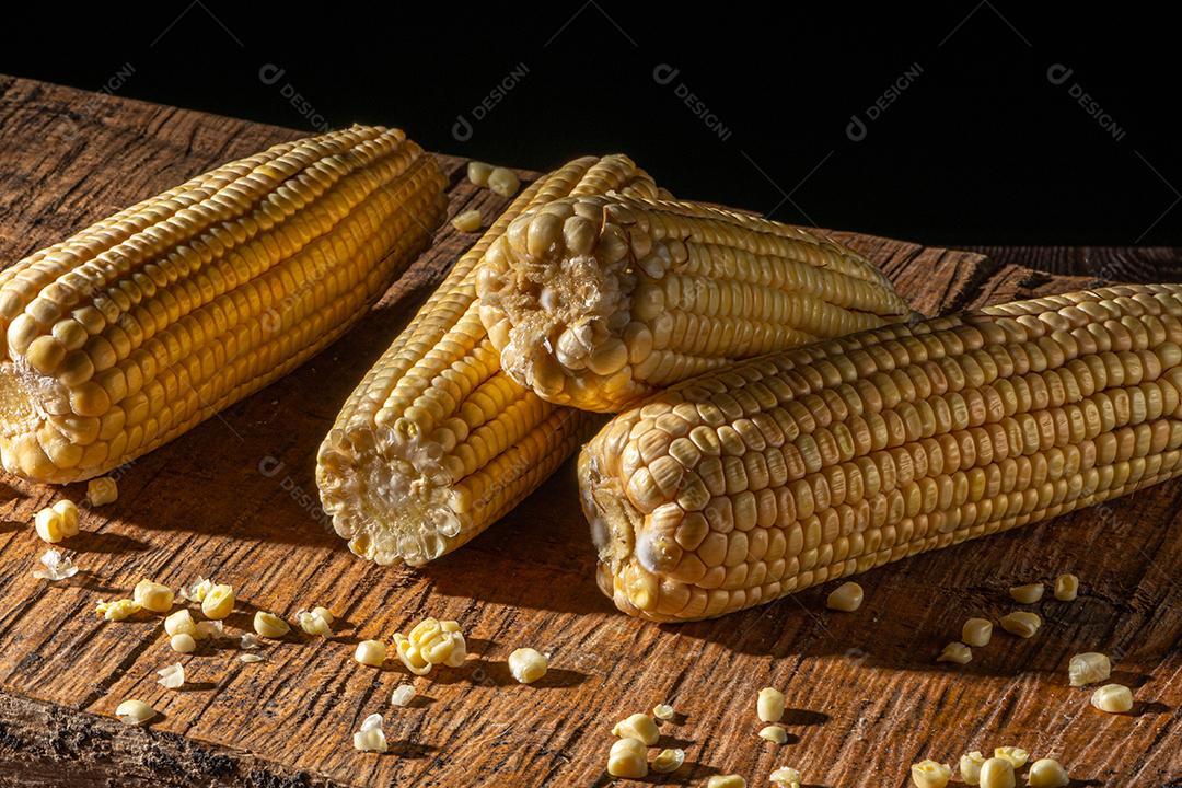 Espiga de milho em fundo de madeira rústica.