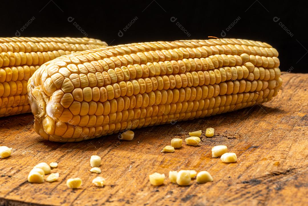 Espiga de milho em fundo de madeira rústica.