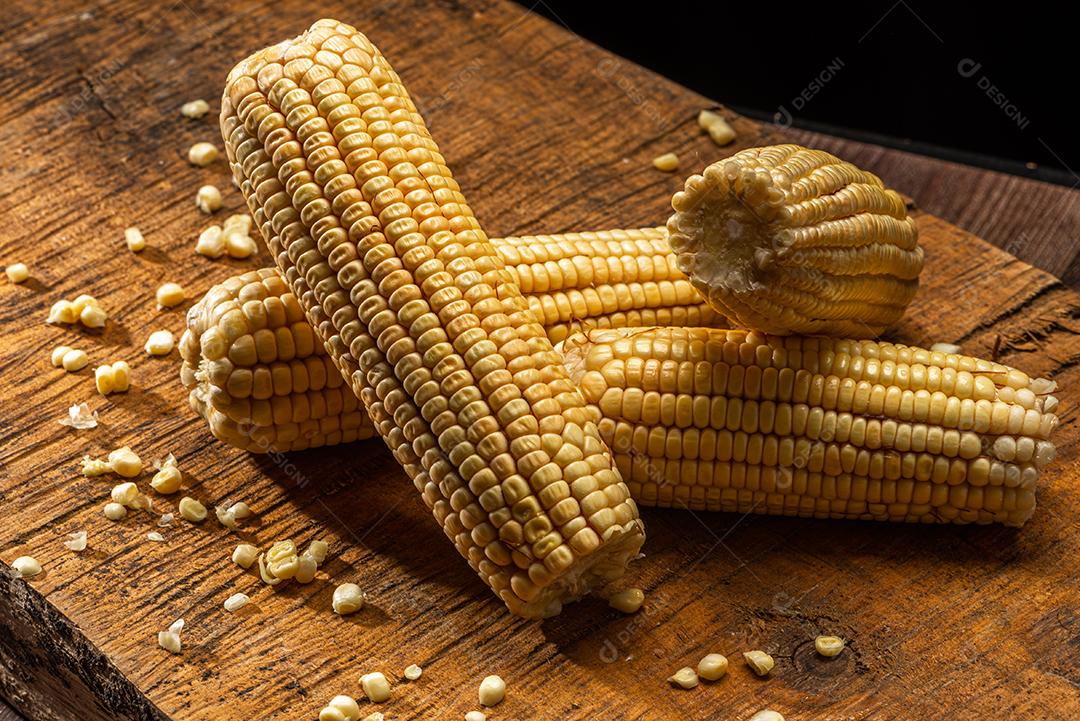 Espiga de milho em fundo de madeira rústica.