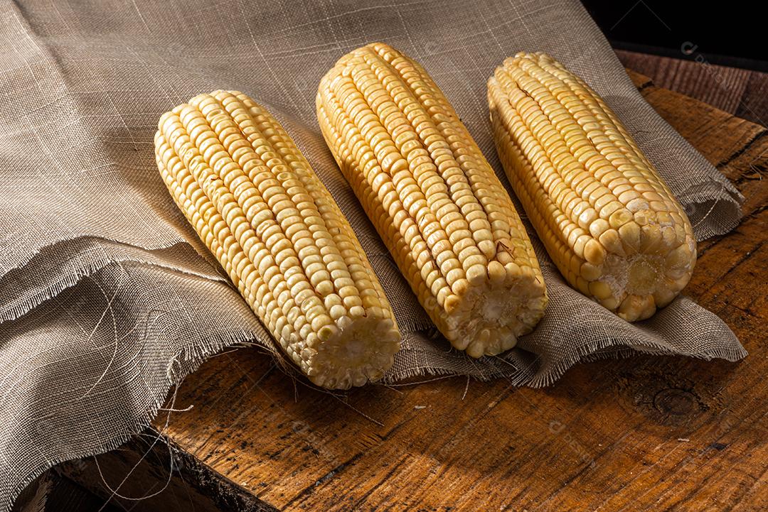 Espiga de milho em fundo de madeira rústica.