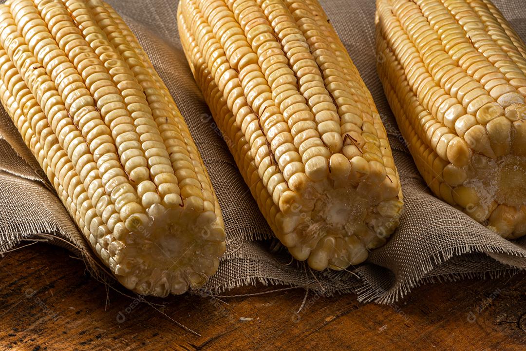 Espiga de milho em fundo de madeira rústica.