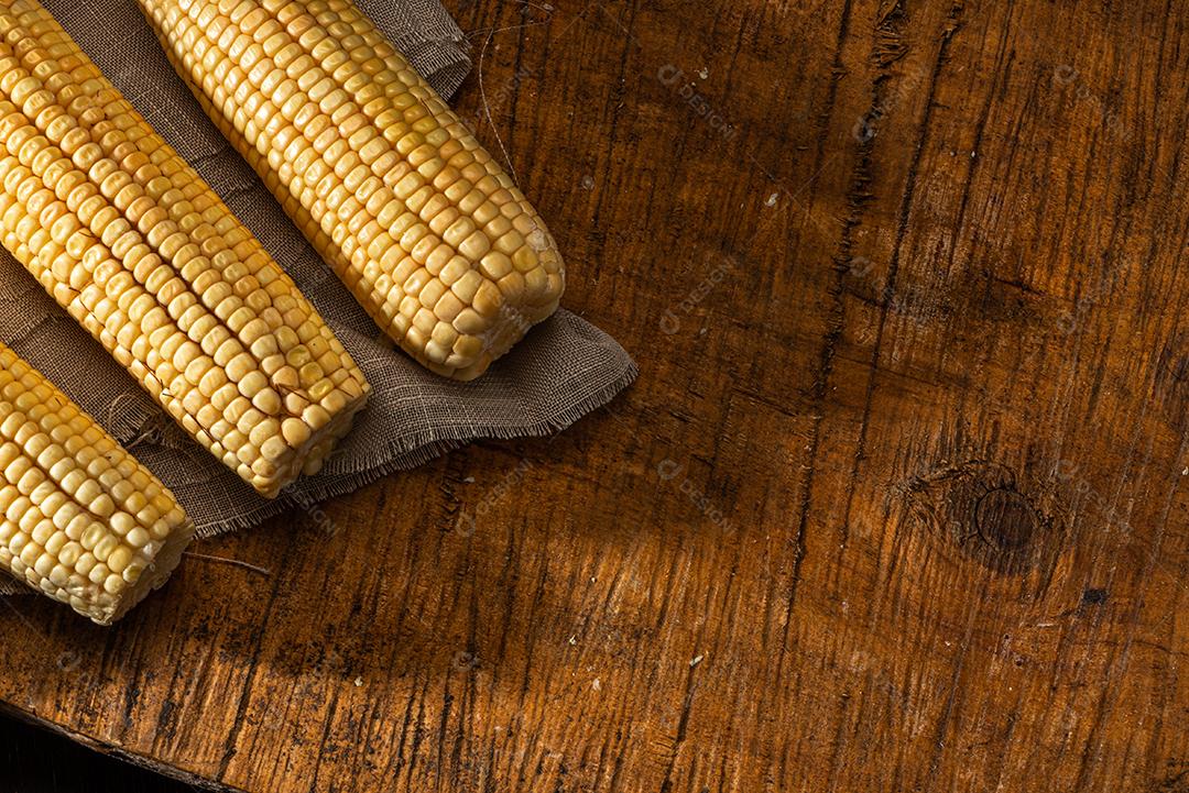 Espiga de milho em fundo de madeira rústica.
