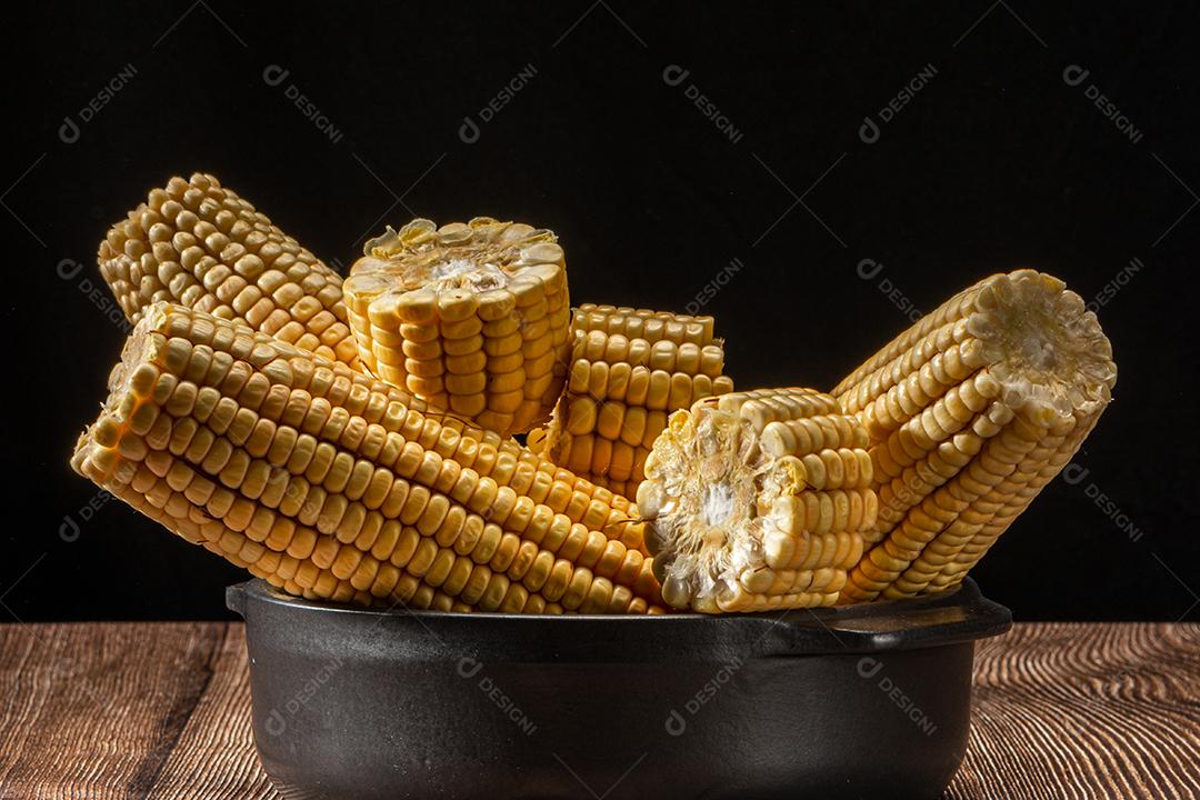 Espiga de milho em fundo de madeira rústica.