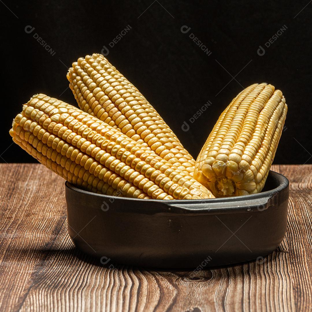 Espiga de milho em fundo de madeira rústica.