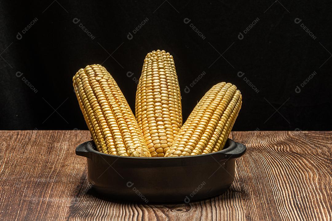 Espiga de milho em fundo de madeira rústica.