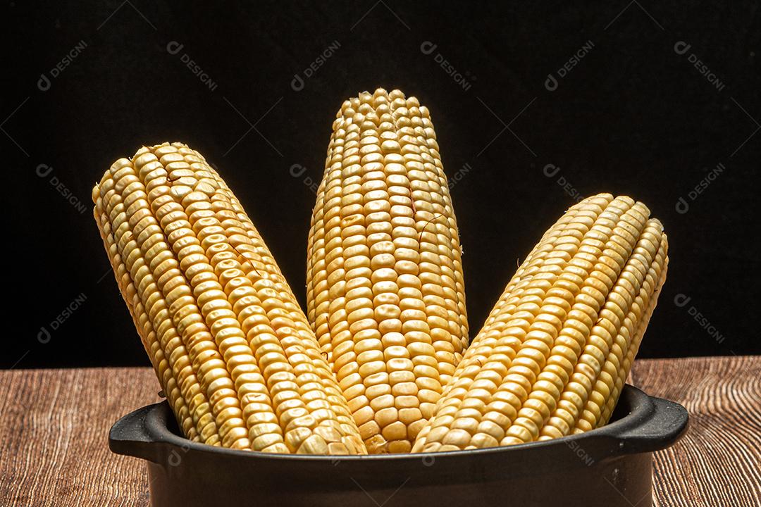 Espiga de milho em fundo de madeira rústica.