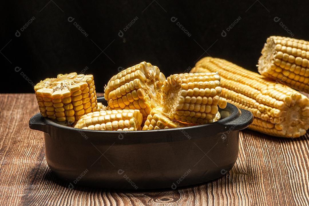 Espiga de milho em fundo de madeira rústica.