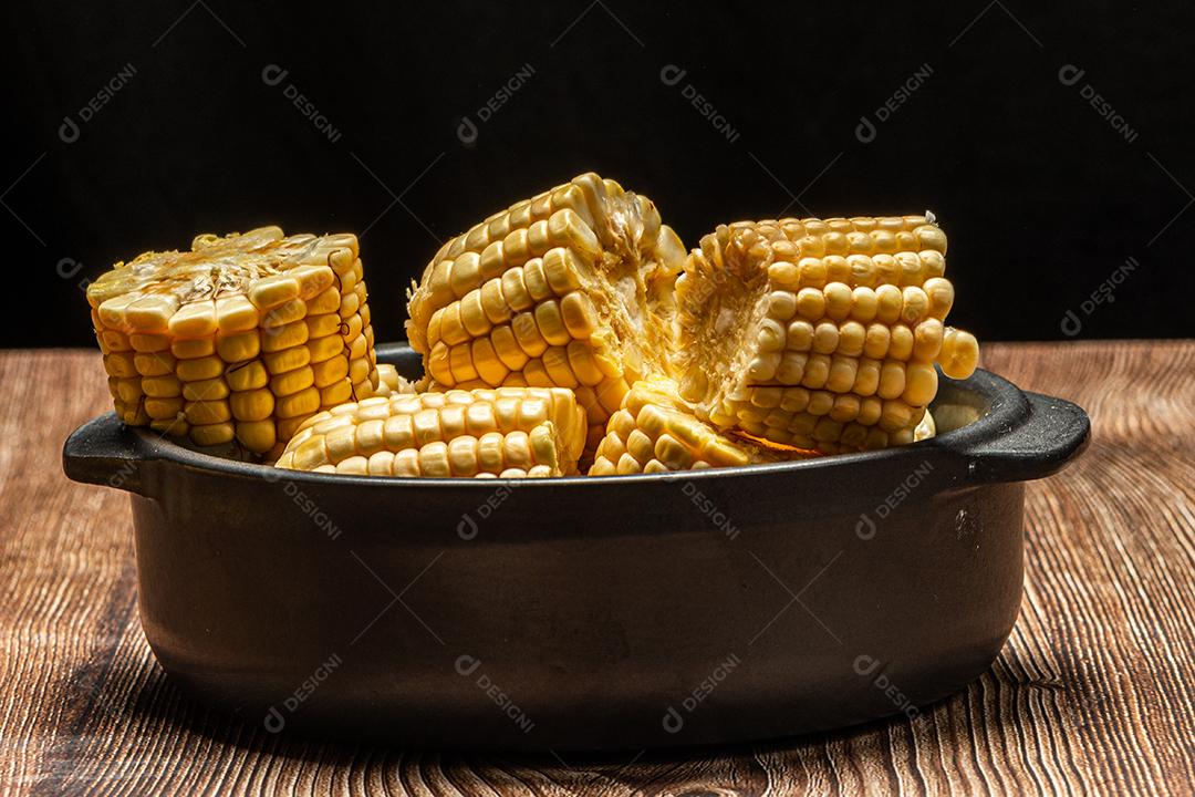 Espiga de milho em fundo de madeira rústica.