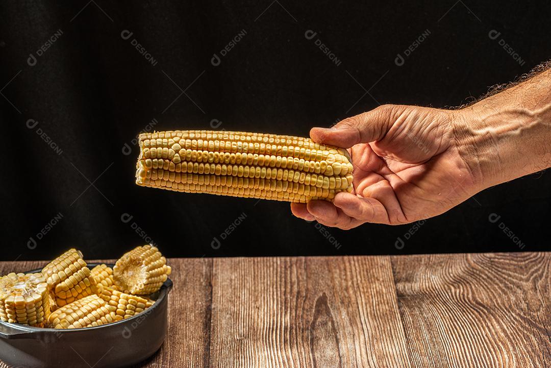 Espiga de milho em fundo de madeira rústica.