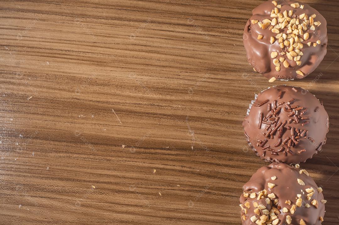 Bolinho de chocolate, muffin de chocolate com castanhas, em uma mesa de madeira