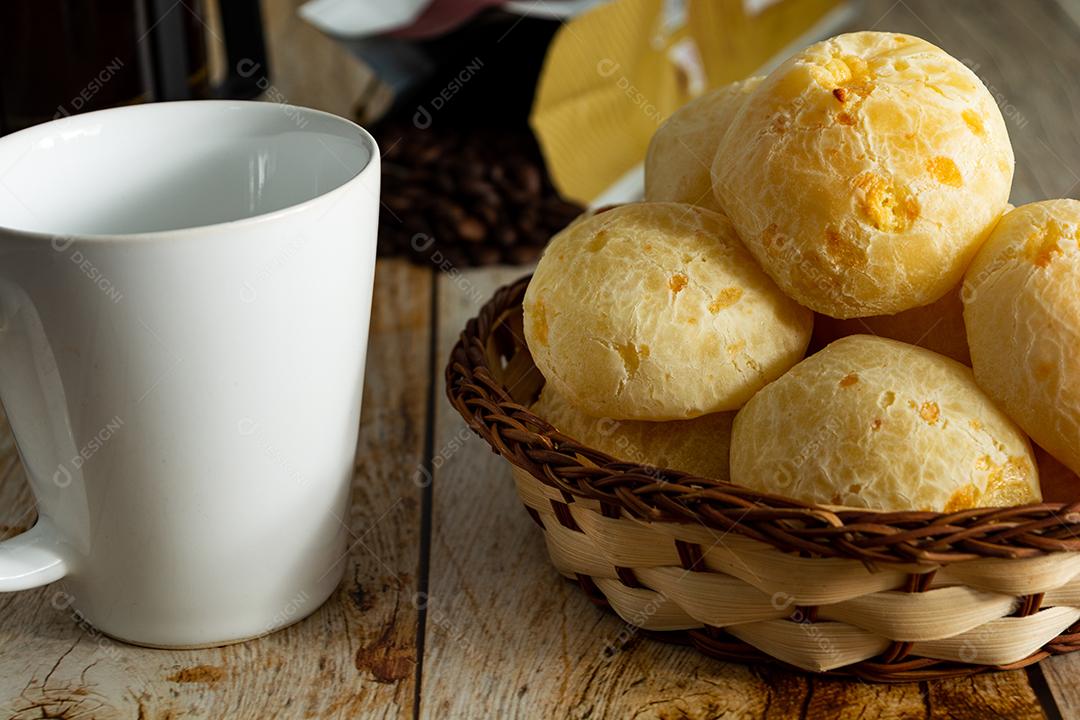 pao de queijo e café sobre uma mesa de madeira