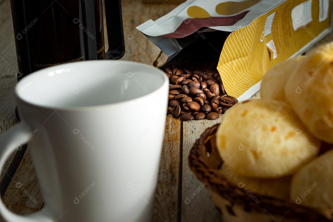 pao de queijo e café sobre uma mesa de madeira
