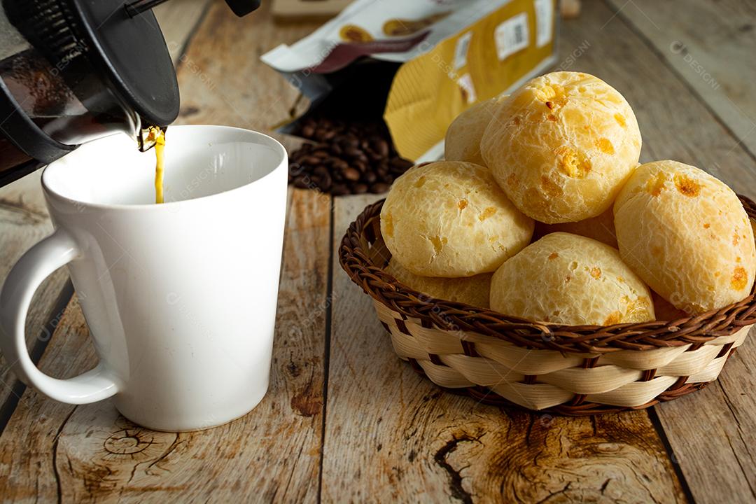 pao de queijo e café sobre uma mesa de madeira