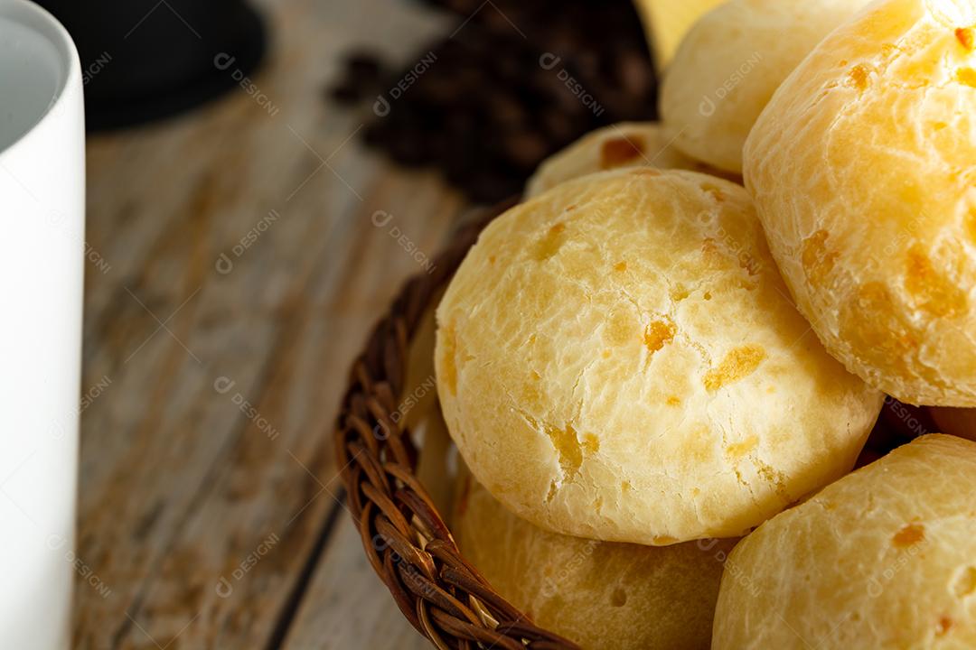 pao de queijo e café sobre uma mesa de madeira
