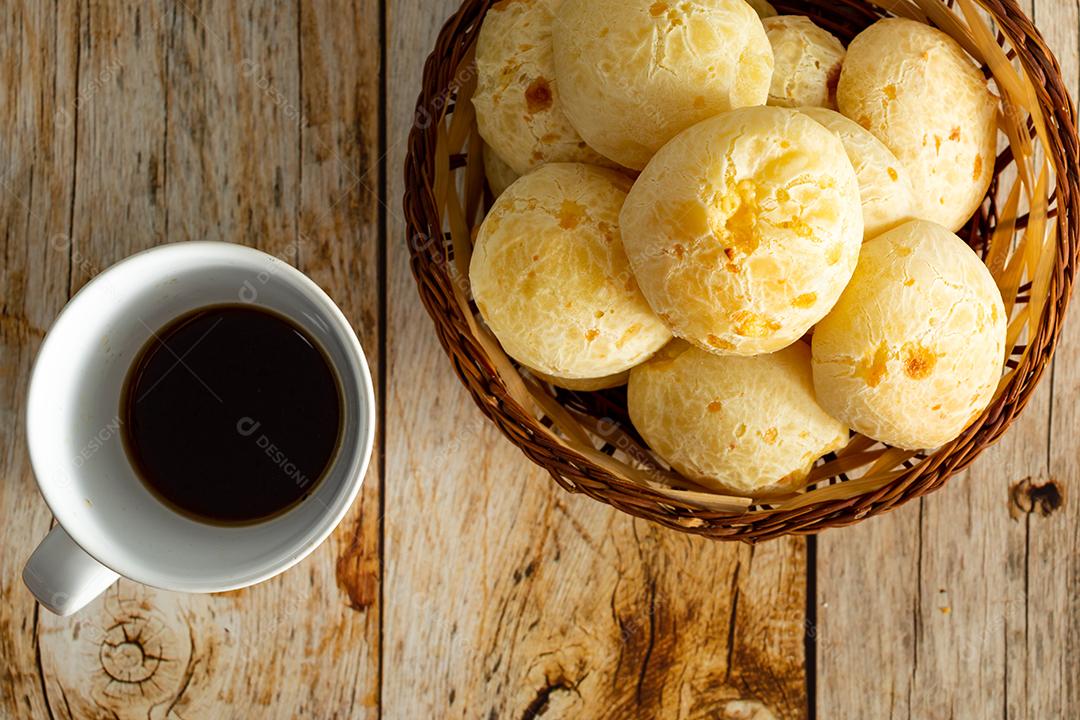 pao de queijo e café sobre uma mesa de madeira