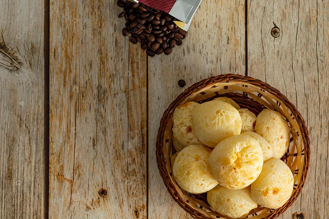 pao de queijo e café sobre uma mesa de madeira