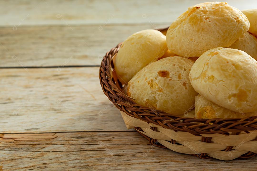 pao de queijo e café sobre uma mesa de madeira