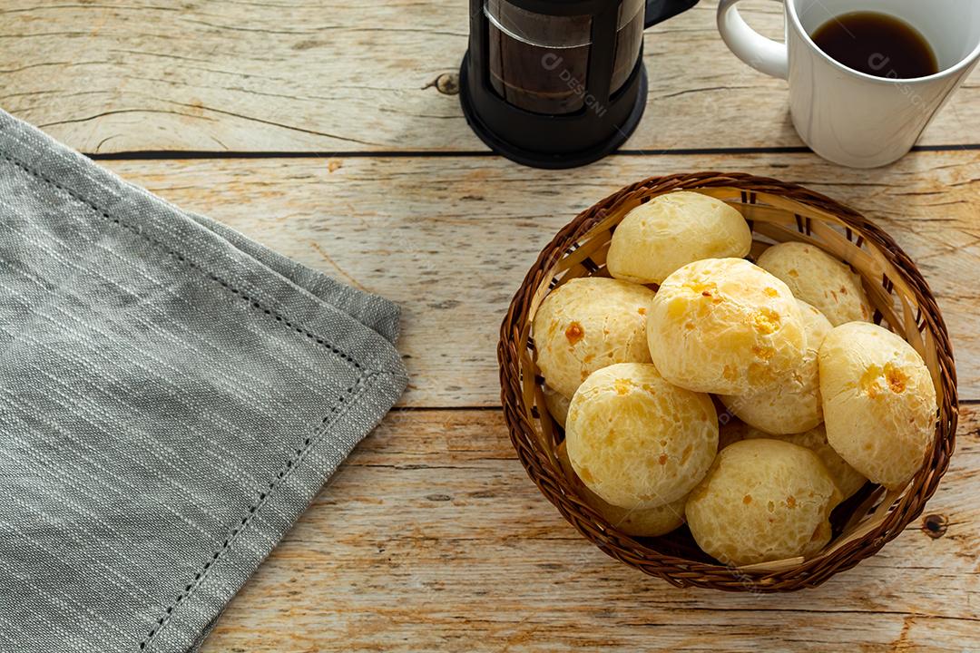 pao de queijo e café sobre uma mesa de madeira