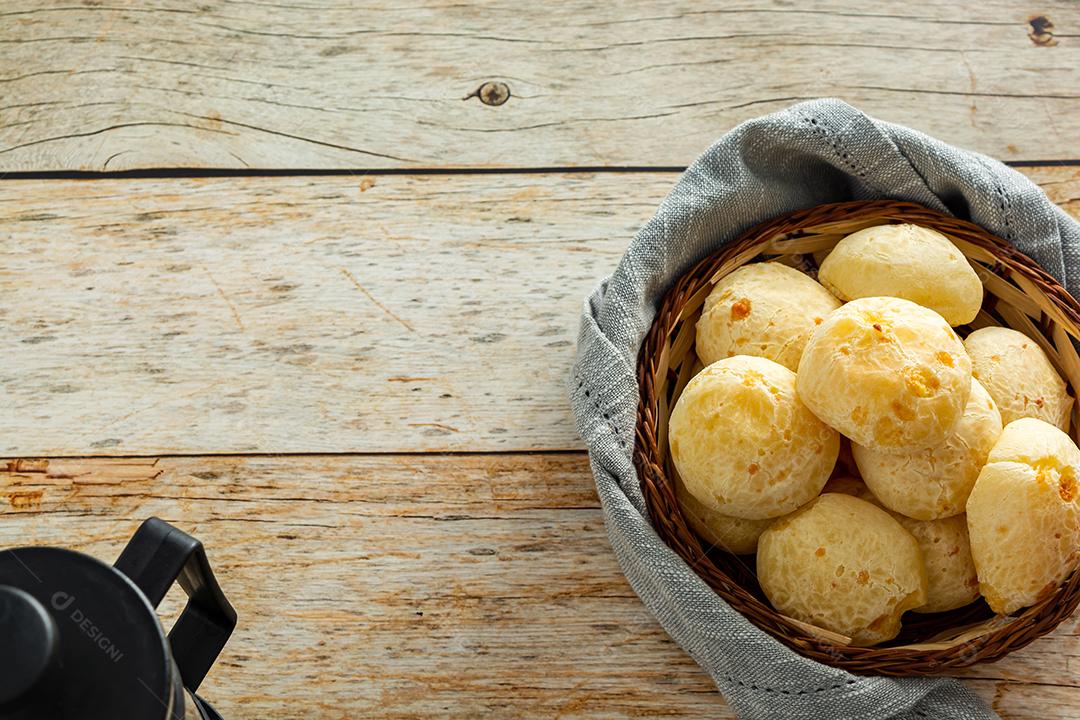 pao de queijo e café sobre uma mesa de madeira