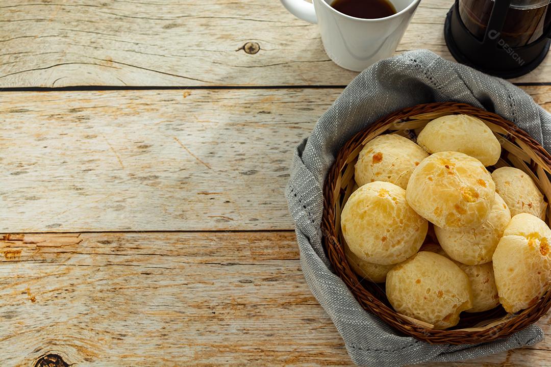 pao de queijo e café sobre uma mesa de madeira