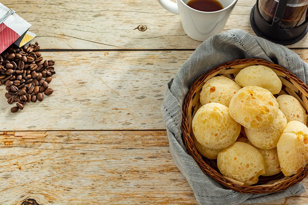 pao de queijo e café sobre uma mesa de madeira