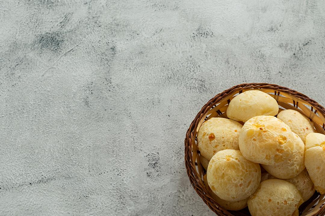 pãõ de queijo em cestinha de madeira em superficie de pedra