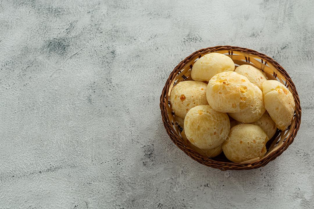 pãõ de queijo em cestinha de madeira em superficie de pedra