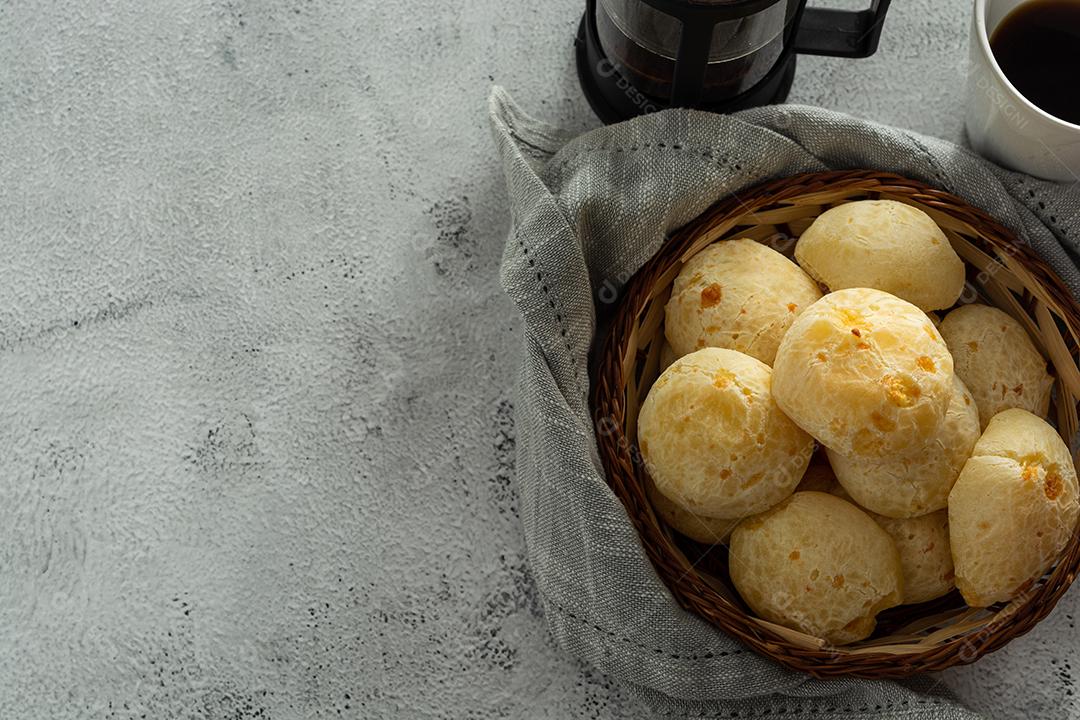 pãõ de queijo em cestinha de madeira em superficie de pedra
