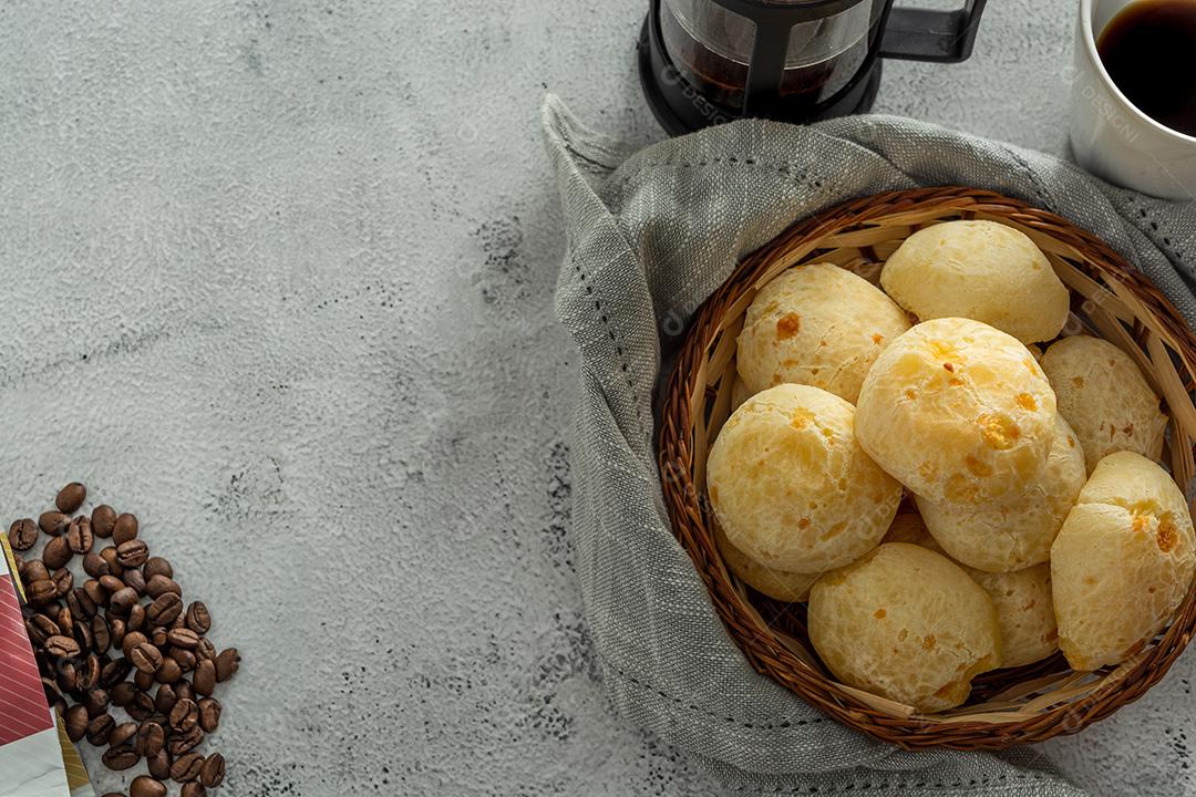 pãõ de queijo em cestinha de madeira em superficie de pedra