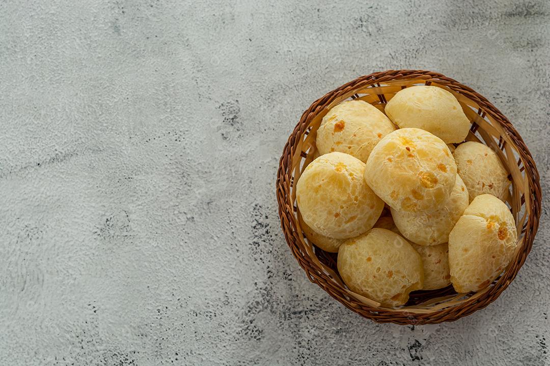 pãõ de queijo em cestinha de madeira em superficie de pedra