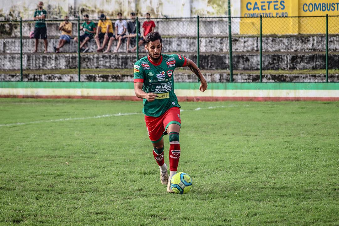 Homem jogador de futebol chutando bola