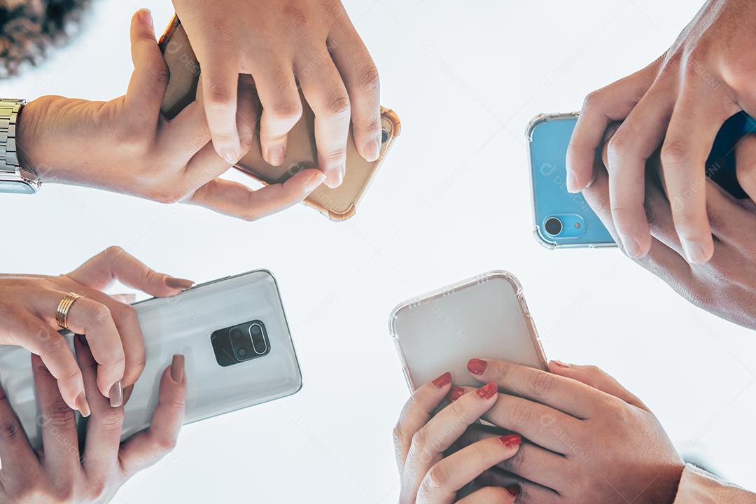 Tiro de grupo adolescente de pessoas usando seus telefones ao ar livre. Conceito de educação, tecnologia e felicidade