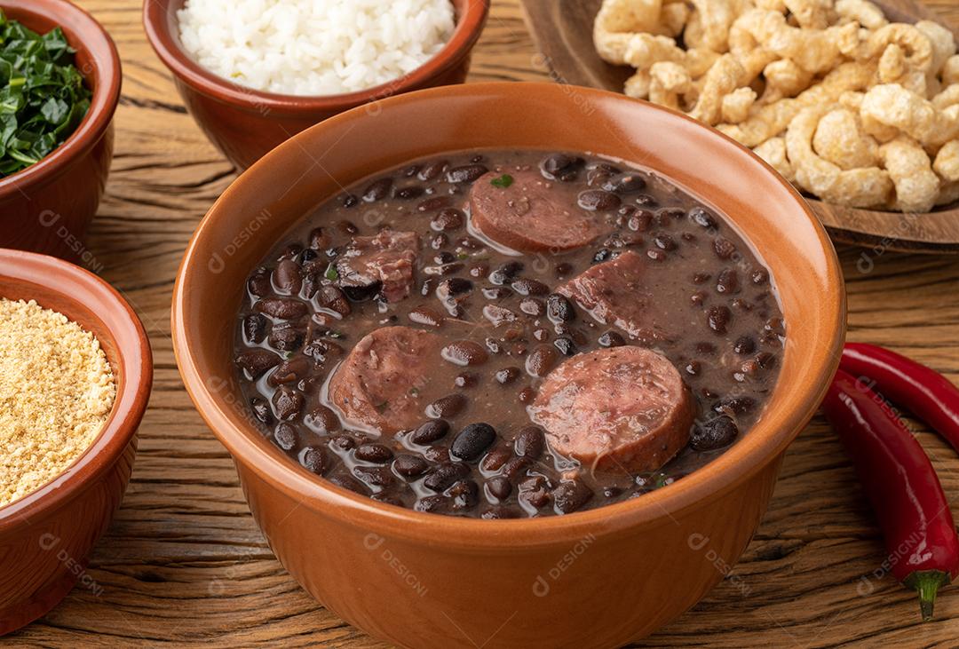 Feijoada típica brasileira com arroz, couve, farofa e torresmo.