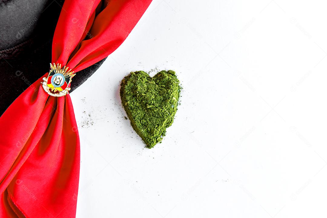 Coração de erva-mate em fundo branco e lenço gaúcho vermelho.