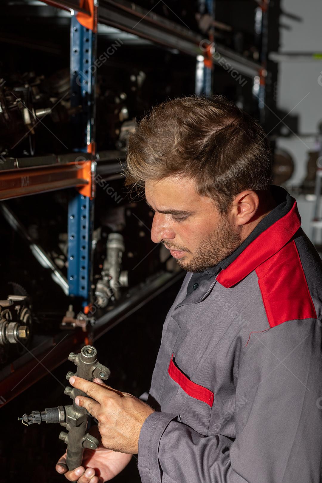 Jovem mecânico trabalhando em uma oficina de automóveis