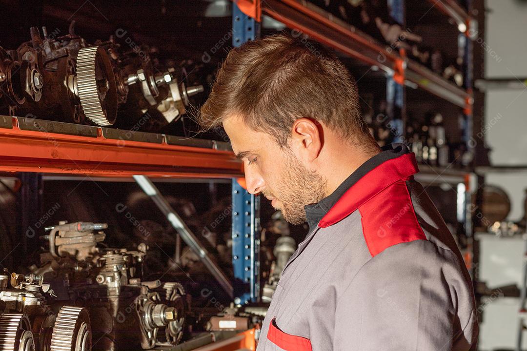 Jovem mecânico trabalhando em uma oficina de automóveis