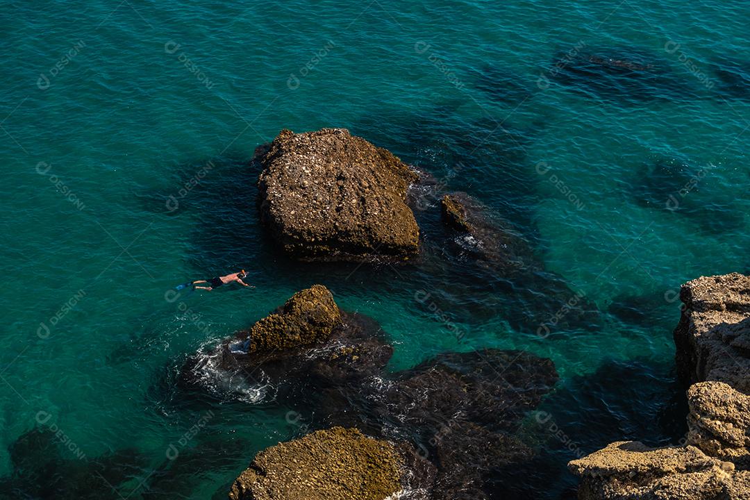 Vista aérea de cima da bela praia de Nerja, na Espanha, com um homem de mergulho.