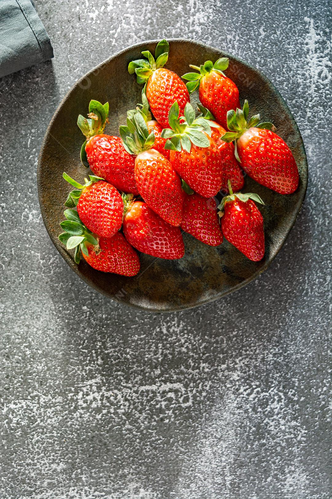 morangos deliciosos e vermelhos em ambiente dark food, preto.