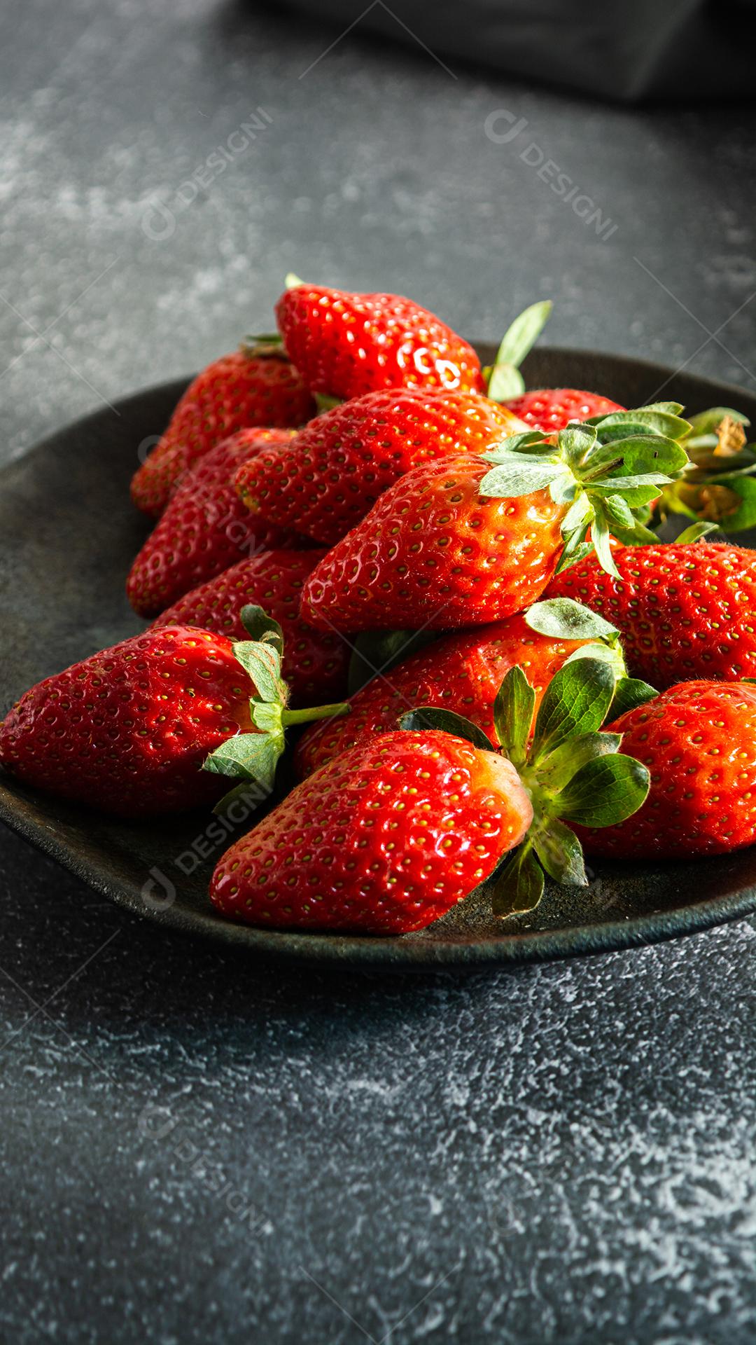 morangos deliciosos e vermelhos em ambiente dark food, preto.