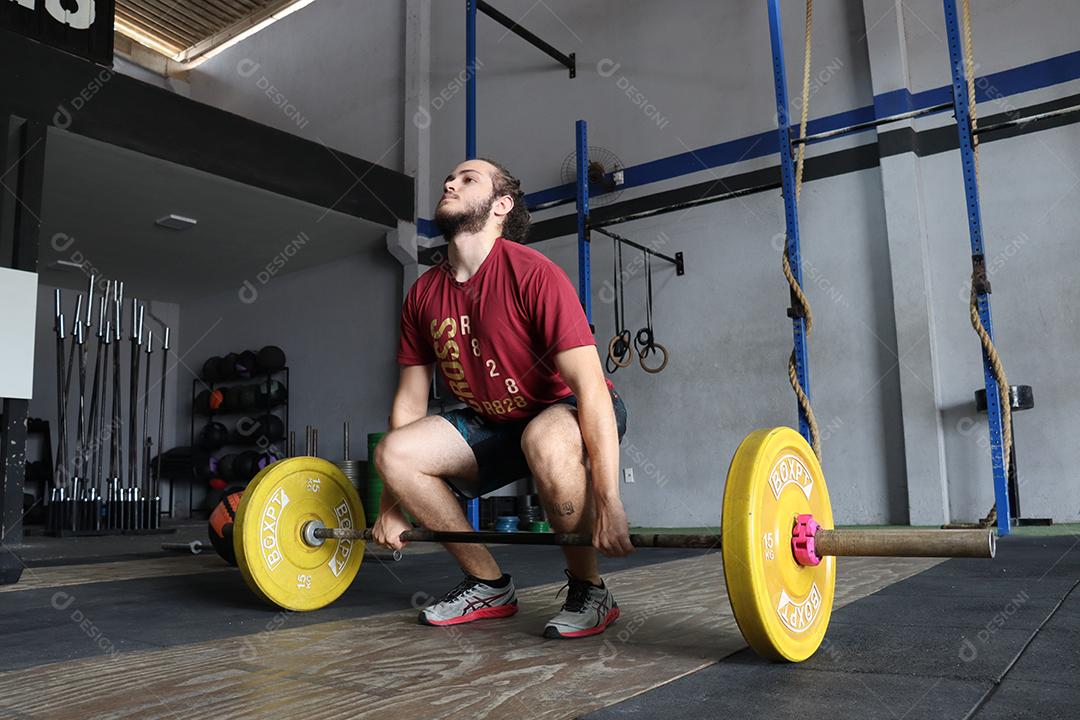 Homem jovem sobre uma academia fazendo musculações Conceito saude melhor