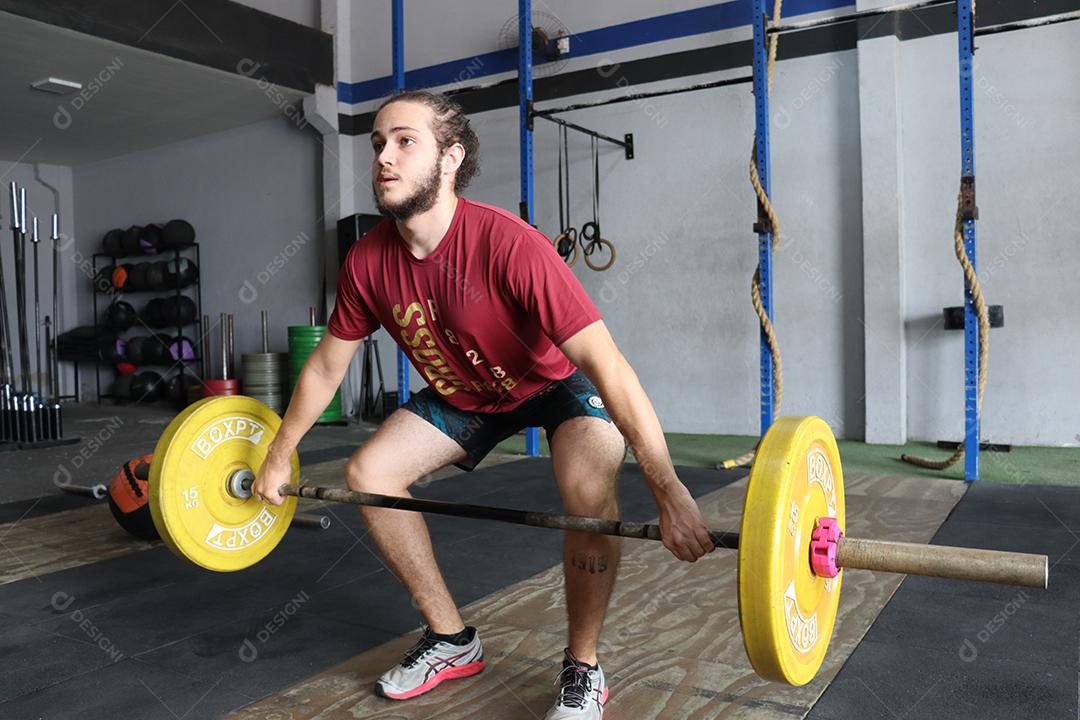 Homem jovem sobre uma academia fazendo musculações Conceito saude melhor